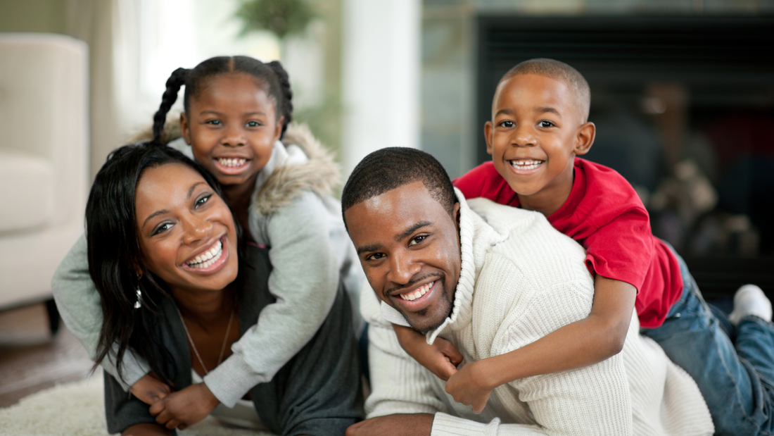 Happy family of four smiling together at home